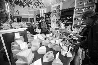 Customers examine the offerings at Rubiner’s Cheesemongers & Grocers in Great Barrington. The store’s owner, Matthew Rubiner, center, has been a serious student of cheese for more than two decades.Scott Langley photo