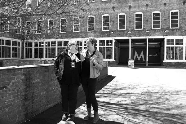 Sue Killam, Mass MoCA’s director of performing arts and film, left, and communications director Jen Falk take a moment to chat in the courtyard outside the museum’s main entrance. Joan K. Lentini photo
