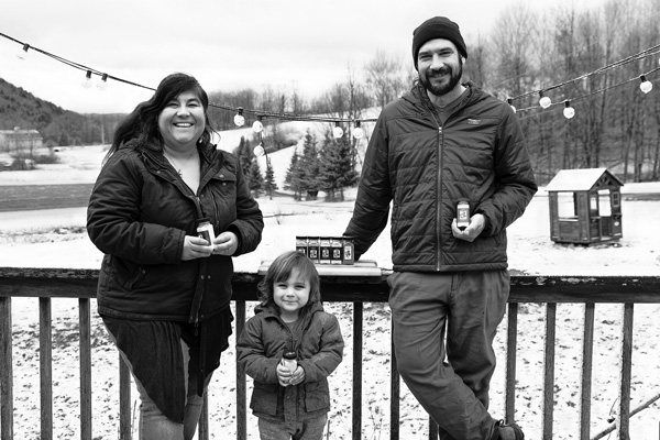Laura Ramos and Adam Fronhofer and their son Tiago, 2, hold jars of the garlic powders they produce from organic garlic grown at their Quill Hill Farm in Poultney, Vt. Joan K. Lentini photo